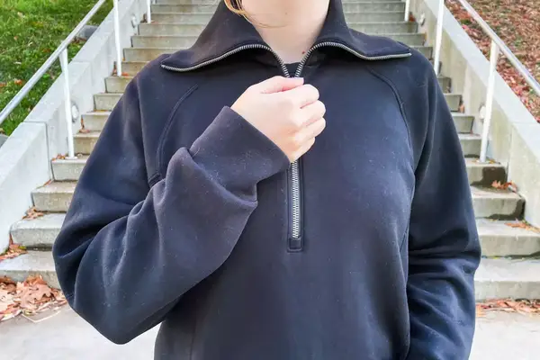 SPANX® AirEssentials Half Zip, Wild Lip Balm, Away the Carry On, Loop Ear plugs, and Sonos Ace Headphones on a grey grid background