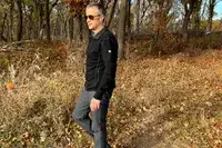 A person wearing the KUHL Interceptr Full-Zip Jacket outdoors