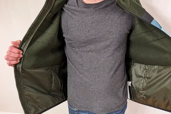 A person wearing the Cotopaxi Teca Fleece Full-Zip Jacket and showing off the inside