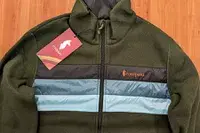Cotopaxi Teca Fleece Full-Zip Jacket laying flat on a wood floor