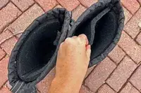 A person removes the liner in a pair of Kamik Men