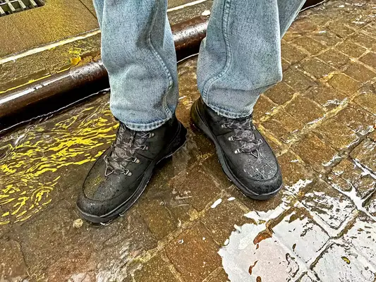 A person stands in water while wearing The North Face Men’s Bergen Leather Waterproof Boots