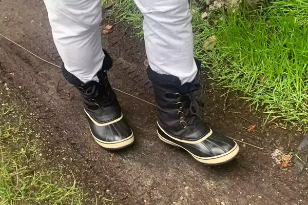 A person walks while wearing the Sorel Menâs 1964 Pac Nylon Boots