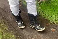 A person walks while wearing the Sorel Menâs 1964 Pac Nylon Boots