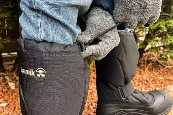 A person cinches the cord on a pair of Kamik Men