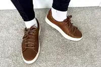 A person posed while wearing the Kizik Women’s Vegas Sneakers on carpet