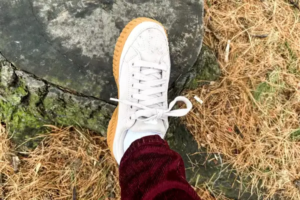 A Sorel Ona Ave Low Waterproof Sneaker worn posed on a rock