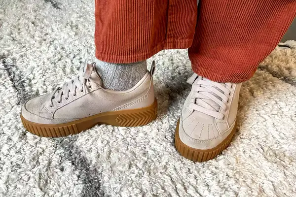 A close-up of the Sorel Ona Ave Low Waterproof Sneakers worn on a rug