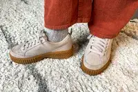 A close-up of the Sorel Ona Ave Low Waterproof Sneakers worn on a rug