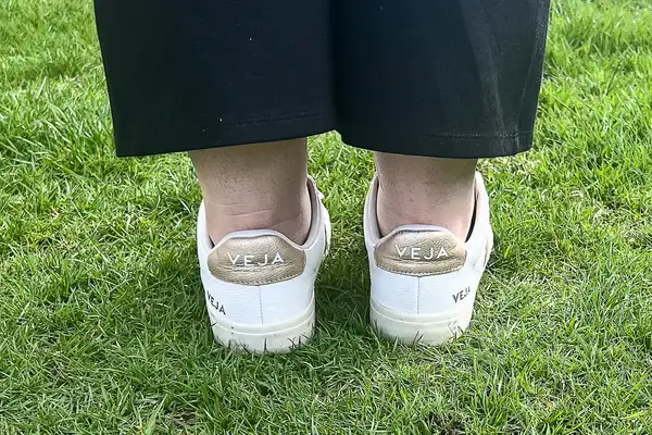 A woman wears Veja Campo Low Top Sneakers in the grass