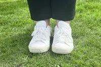 A woman wears Veja Campo Low Top Sneakers in the grass