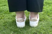 A woman wears Veja Campo Low Top Sneakers in the grass