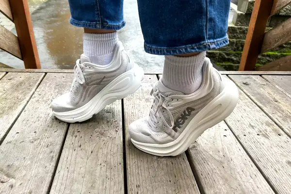 A close-up of a person on their tippy-toes while wearing the Hoka Bondi 9 shoes