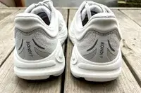 The back of the Hoka Bondi 9 shoes posed on wood