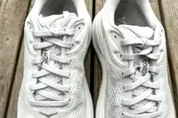 A close-up of the laces on the Hoka Bondi 9 shoes placed on wood