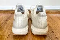 The back of the Adidas Ultraboost 1.0 sneakers posed on a wooden floor