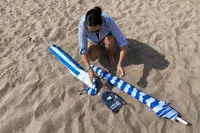 A person pulling the OutdoorMaster Beach Umbrella out of it