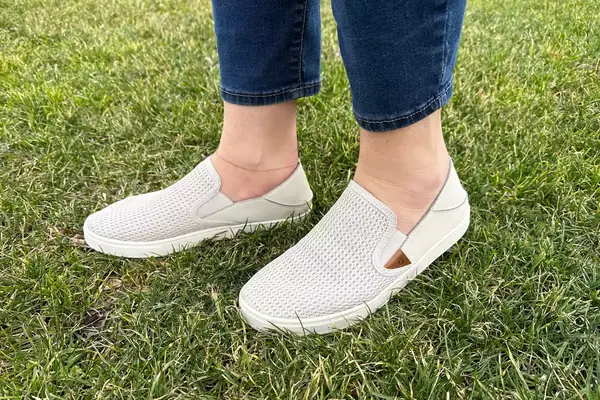 A woman wearing OluKai Pehuea Slip On Sneakers.