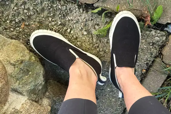 A person wearing OluKai Pehuea Slip On Sneakers.