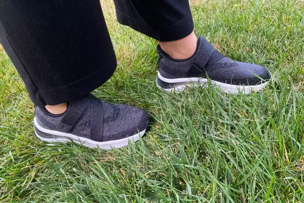 A person walks through grass while wearing the Orthofeet Women