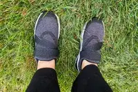 A person stands in grass while wearing the Orthofeet Women