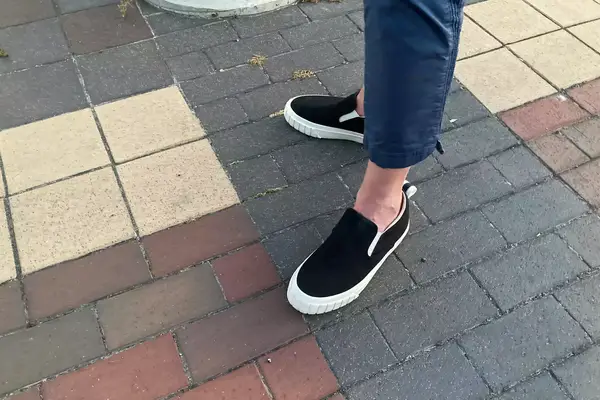 A woman wearing OluKai Pehuea Slip On Sneakers.