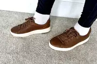 A person posed on carpet while wearing the Kizik Women’s Vegas Sneakers