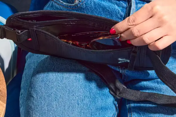 A person places sunglasses into the Molarun Travel Money Belt