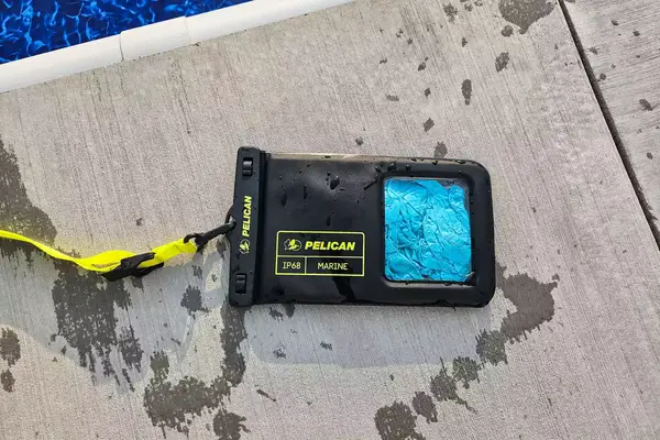 A wet Case-Mate Pelican Marine IP68 Waterproof Phone Pouch on concrete