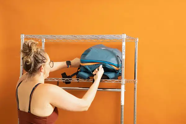 Two hands holding the EPICKA Universal Travel Adapter plugged into the wall