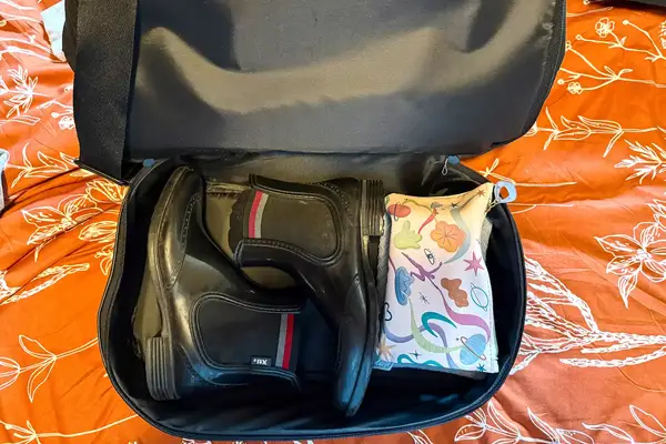 The bottom compartment of Béis Mini Weekender unzipped showing a pair of shoes inside