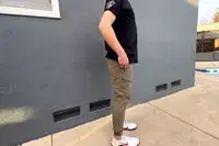 A person posing to the side while wearing the Nomatic Outset Jogger