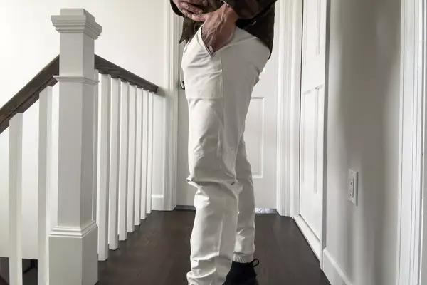 A person stands sideways in a hallway wearing the lululemon License to Train Jogger