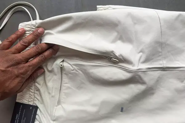 A person examines the zippered pocket on the lululemon License to Train Jogger