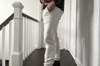 A person stands sideways in a hallway wearing the lululemon License to Train Jogger