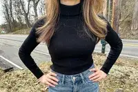 A person wearing the Uniqlo Merino Ribbed Sweater