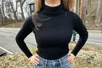 A person wearing the Uniqlo Merino Ribbed Sweater