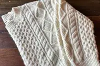 Buck Mason Cable Crew laying on a hardwood floor