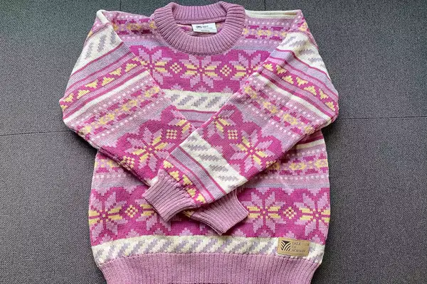 Flatlay of the Dale of Norway Ingrid Sweater on a grey surface