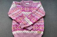 Flatlay of the Dale of Norway Ingrid Sweater on a grey surface