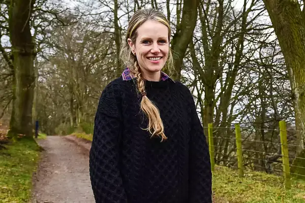 A person standing outside wearing the Aran Sweater Market Men