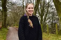 A person standing outside wearing the Aran Sweater Market Men