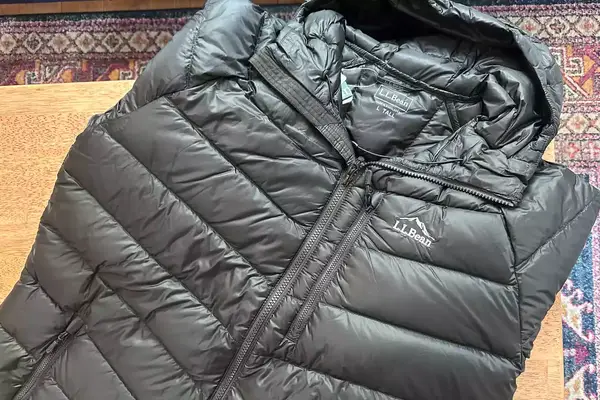 The L.L. Bean Mens Ultralight 850 Down Hooded Jacket folded on a table