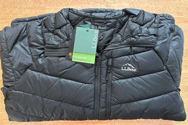 The L.L. Bean Mens Ultralight 850 Down Hooded Jacket folded on a table