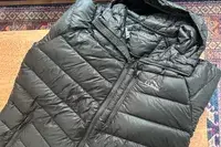 The L.L. Bean Mens Ultralight 850 Down Hooded Jacket folded on a table
