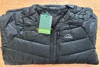 The L.L. Bean Mens Ultralight 850 Down Hooded Jacket folded on a table