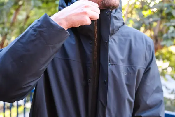 A person zips up the Cotopaxi Calidez Men