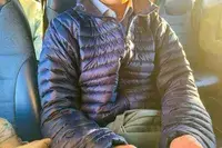 A person sits on a bus while wearing the Marmot Men