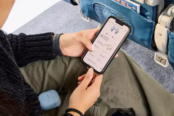 Two hands holding the a phone displaying the Bose QuietComfort Ultra Earbuds app