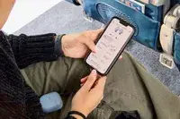 Two hands holding the a phone displaying the Bose QuietComfort Ultra Earbuds app